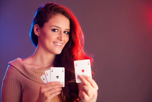 Beautiful brunette holding four aces as a sign for poker game, g — Stock Photo, Image