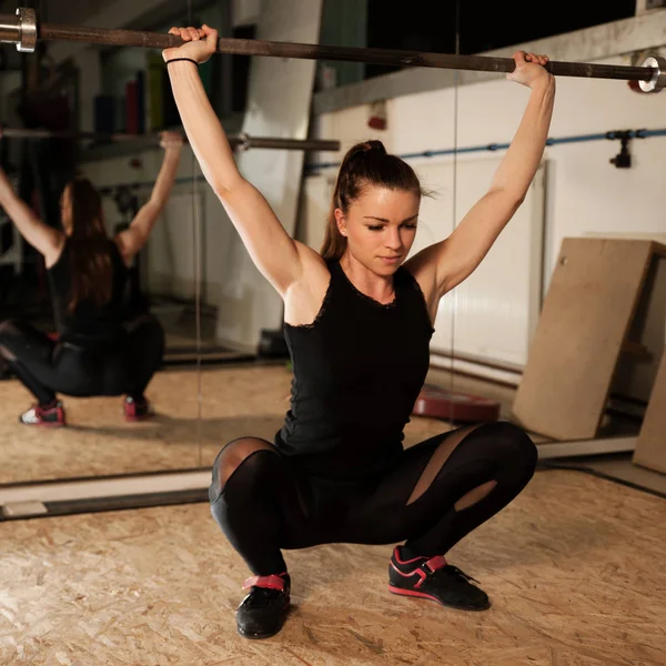 女人锻炼在健身房与杠铃-力 workou — 图库照片