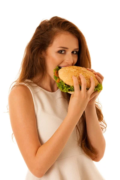 不健康的膳食-幸福的年轻女人吃汉堡包在孤立 — 图库照片