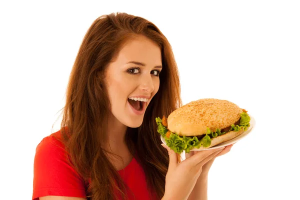 Ongezonde maaltijd - gelukkige jonge vrouw eet hamburger geïsoleerd via — Stockfoto