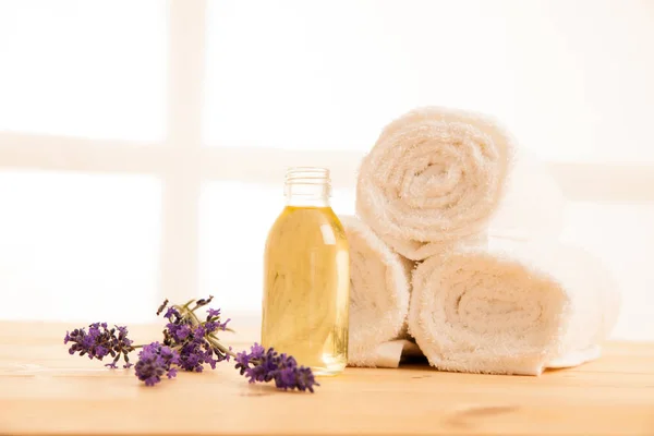 Toallas de lavanda y aceite de masaje en una mesa en el salón de spa —  Fotos de Stock