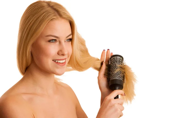 Hermosa mujer rubia cepillándose el cabello como una señal de cuidado del cabello og —  Fotos de Stock