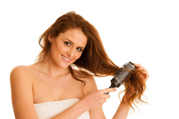 Beautiful young woman combs her hair with a brush isolated over — Stock Photo, Image