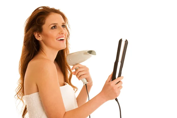 Beautiful young woman holds hair brush and blow dryer isolated o — Stock Photo, Image