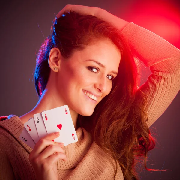 Beautiful brunette holding four aces as a sign for poker game, g — Stock Photo, Image