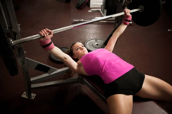 Entrenamiento de mujer en gimnasio con barra de pesas - entrenamiento de levantamiento de pesas —  Fotos de Stock