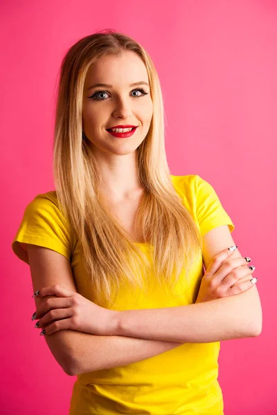Leuke jonge blonde tiener vrouw poseren op roze achtergrond in vib — Stockfoto