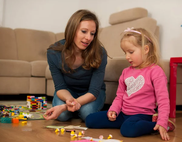 Kinderen en hun moeder spelen met blokken op de grond — Stockfoto