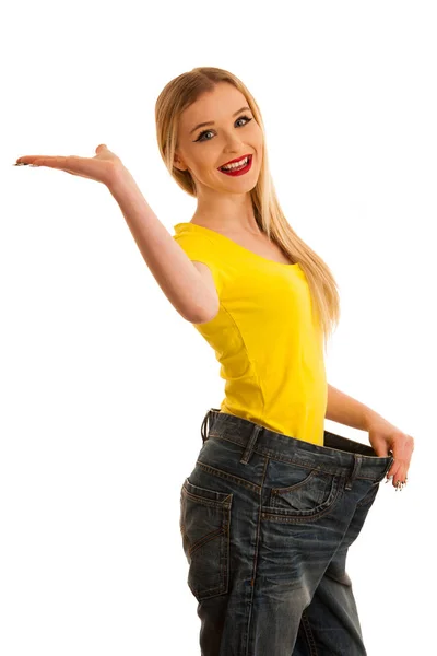 Frau gestikuliert Erfolg, als sie Gewicht verloren trägt zu große Hose — Stockfoto
