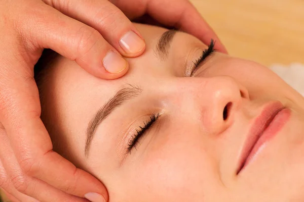 Mulher loira bonita com uma massagem facial no salão de spa — Fotografia de Stock