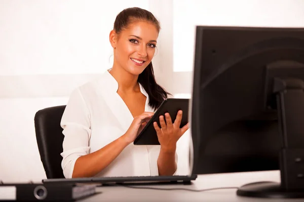 Business woman browsing internet on her tablet in office — Stock Photo, Image