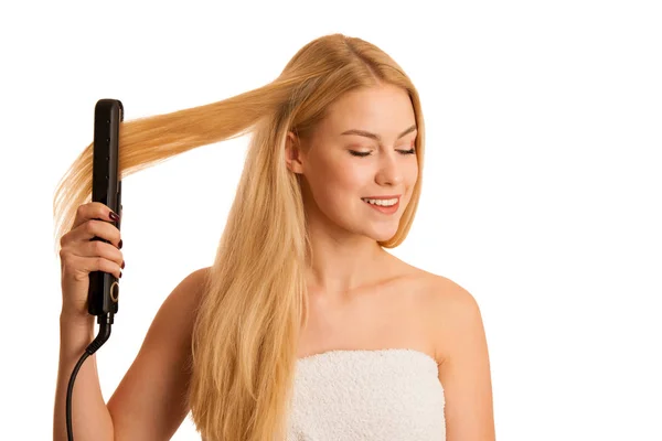 Женщина выпрямляет волосы на белом фоне — стоковое фото