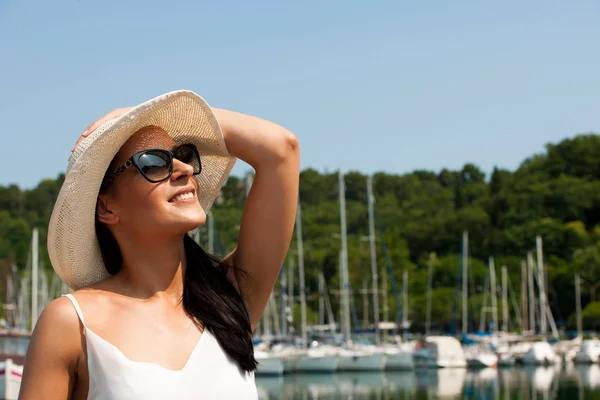 Giovane donna con cappello vestito estivo e occhiali da sole passeggiate molo di m — Foto Stock