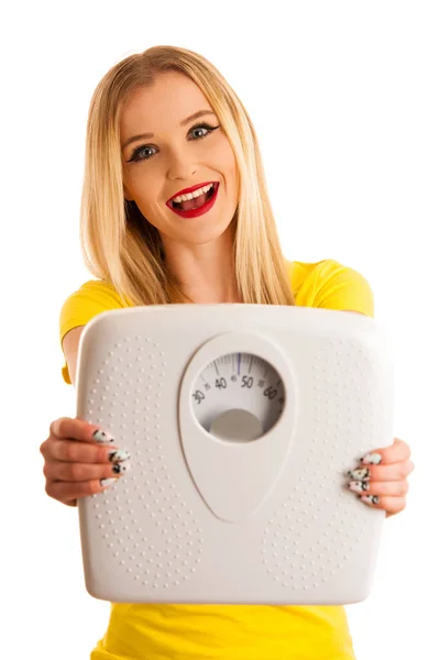 Mujer joven sosteniendo una balanza como gesto para el peso suelto aislado — Foto de Stock