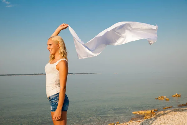 Schönes Mädchen mit weißem Stoff am Strand. Reisen und Urlaub — Stockfoto