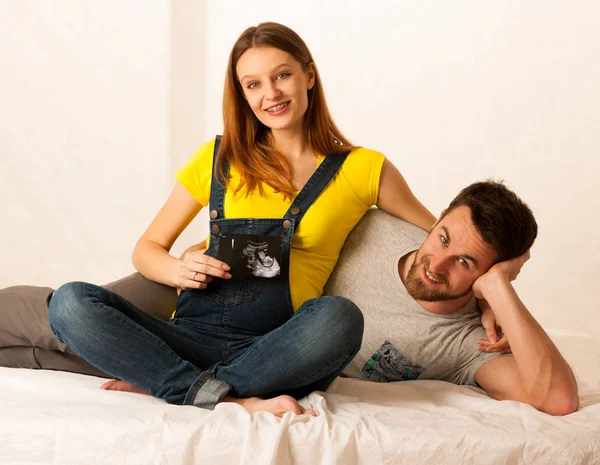 Glückliches Paar Mann und schöne schwangere Frau zeigen mit Ultrasou — Stockfoto