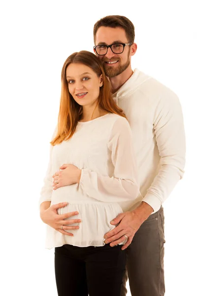 Красивая беременная женщина и мужчина стоят изолированно над белым  - — стоковое фото