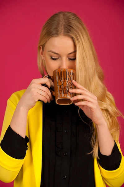 Hermosa joven bebe café sobre fondo rosa — Foto de Stock