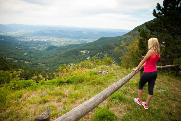 Donna riposa alla recinzione dopo l'allenamento in natura — Foto Stock