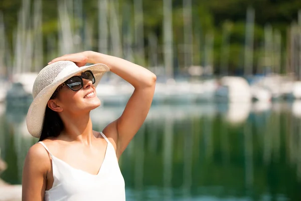 Junge Frau mit Hut Sommerkleid und Sonnenbrille geht Pier von m — Stockfoto