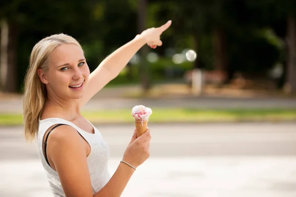 Женщина ест мороженое в парке в жаркий летний день — стоковое фото