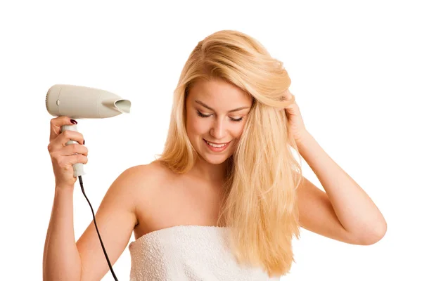 Blonde woman drieing her hair with air blower isolated over whit — Stock Photo, Image