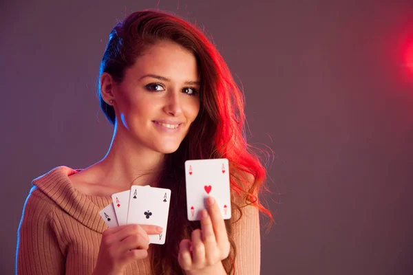 Beautiful brunette holding four aces as a sign for poker game, g — Stock Photo, Image