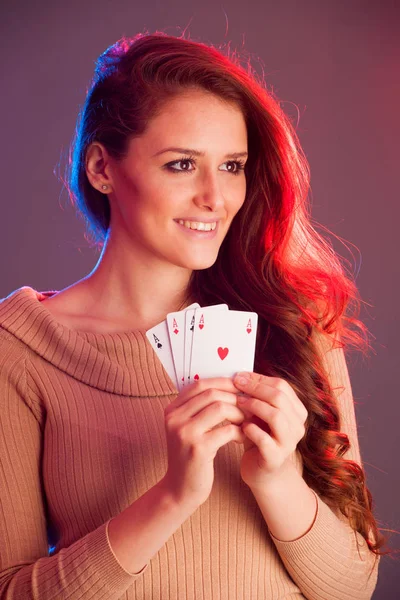 Hermosa morena sosteniendo cuatro ases como un signo para el juego de póquer, g —  Fotos de Stock
