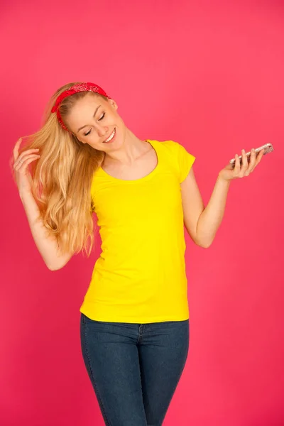 Beautiful young blond teenage woman in yellow t shirt  taking se — Stock Photo, Image