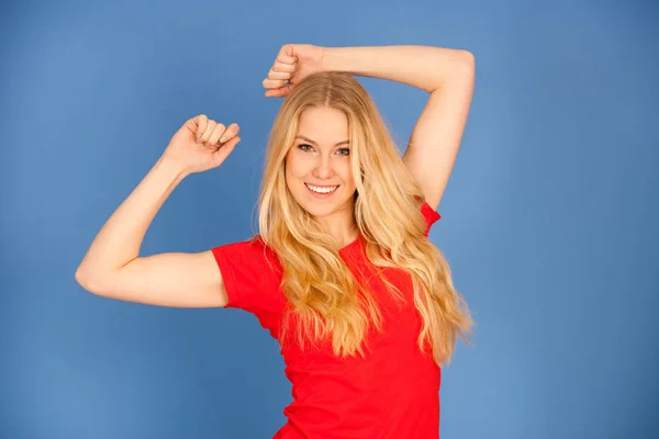 Mooie jonge blonde tiener vrouw in levendige t shirt dans iso — Stockfoto