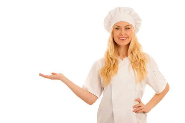 Young blonde chef points to copy space as she presents a new rec — Stock Photo, Image