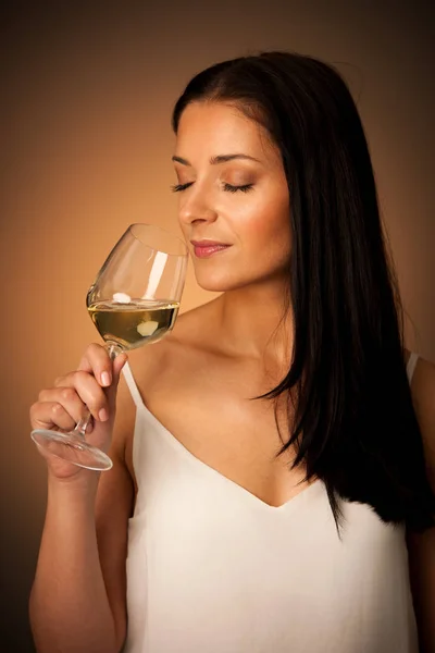 Junge brünette Frau mit einem Glas Weißwein — Stockfoto