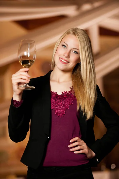 Bella giovane donna bionda beve vino in cantina — Foto Stock