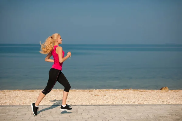 Jogging w th beach - kobieta aplikacja działa w pobliżu morza na początku lata jes — Zdjęcie stockowe