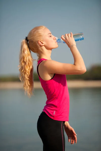 Mujer descansa después del entrenamiento matutino en la playa — Foto de Stock