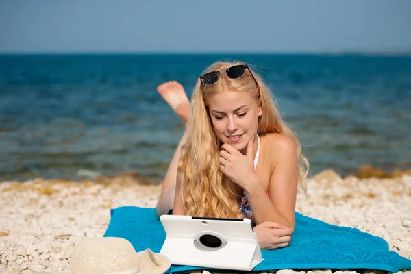 Frau surft im Internet und schaut auf Tablet am Strand — Stockfoto