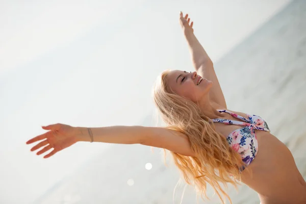 Piękna młoda kobieta korzystać na plaży z rękami do góry - sukces — Zdjęcie stockowe