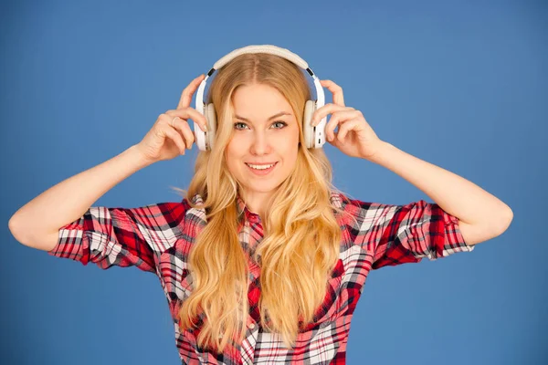 Jovem loira com fones de ouvido escuta a música sobre bl — Fotografia de Stock