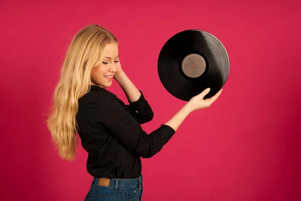 Hermosa joven sosteniendo un vinilo en sus manos mientras escucha —  Fotos de Stock