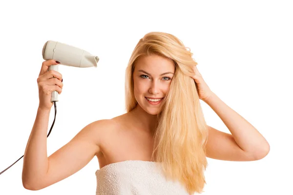 Blonde woman drieing her hair with air blower isolated over whit — Stock Photo, Image