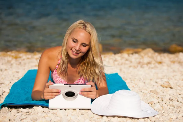 Frau surft im Internet und schaut auf Tablet am Strand — Stockfoto