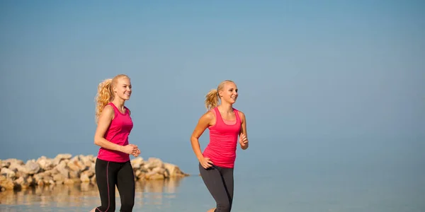 Athlets van de twee vrouwen lopen op het strand - vroege ochtend zomer w — Stockfoto