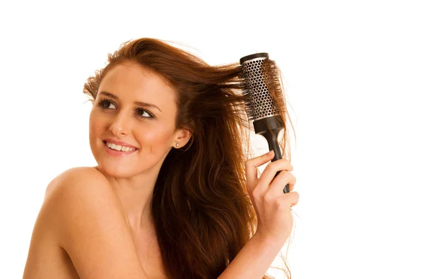 Mulher bonita penteia o cabelo com uma escova isolada sobre — Fotografia de Stock