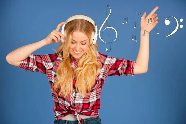 Joven mujer rubia con auriculares escucha la música sobre bl —  Fotos de Stock