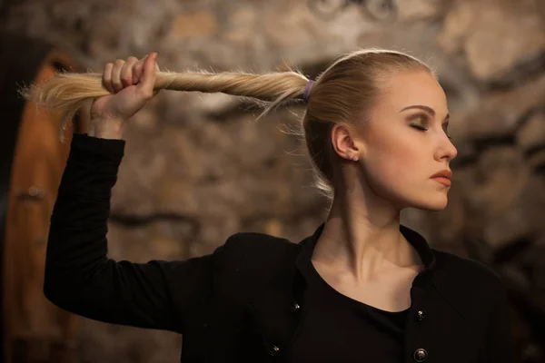 Schöne junge blonde Frau trinkt Wein im Weinkeller — Stockfoto