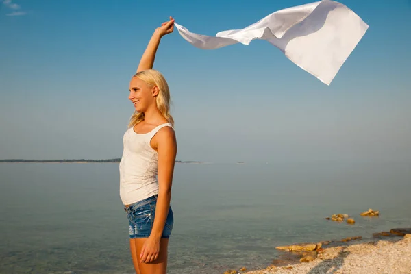 Красивая девушка с белой тканью на пляже. Путешествия и отдых — стоковое фото