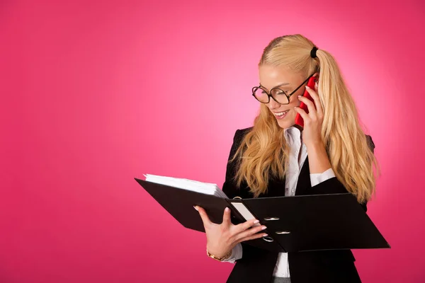 Mujer de negocios sosteniendo una carpeta y hablando por teléfono — Foto de Stock