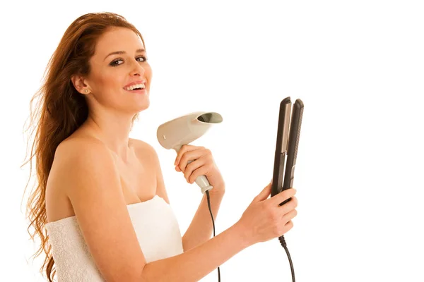 Beautiful young woman holds hair brush and blow dryer isolated o — Stock Photo, Image