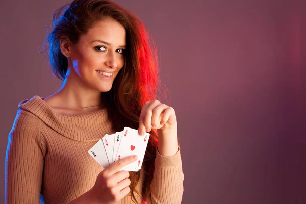 Hermosa morena sosteniendo cuatro ases como un signo para el juego de póquer, g — Foto de Stock