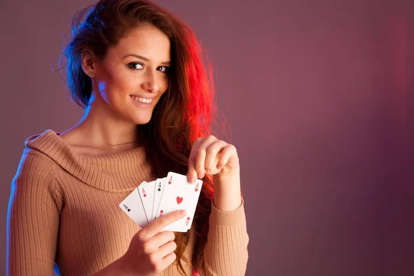 Beautiful brunette holding four aces as a sign for poker game, g — Stock Photo, Image